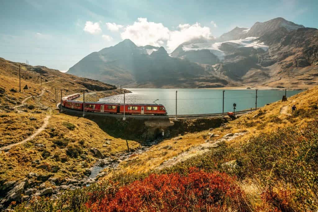 Rhaetische Bahn RhB am Lago Bianco auf dem Berninapass mit Piz Bernina im Herbst.