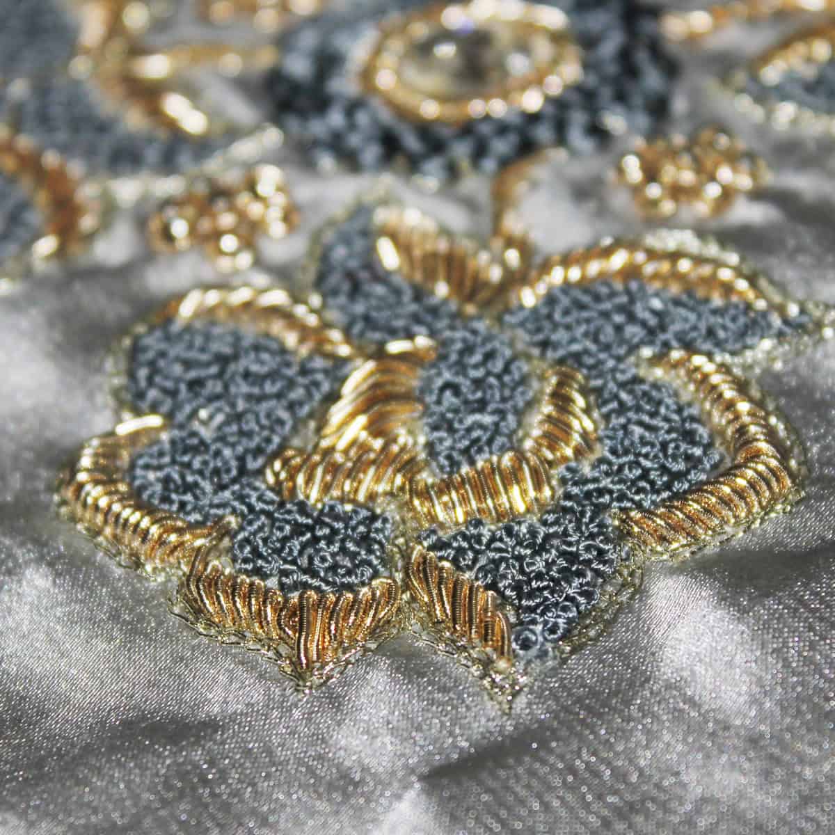 The technique uses gold and silver threads, often combined with sequins, pearls, and precious stones, embroidered onto rich fabrics such as velvet, satin, and silk. Image courtesy: Zarood via Wikimedia Commons