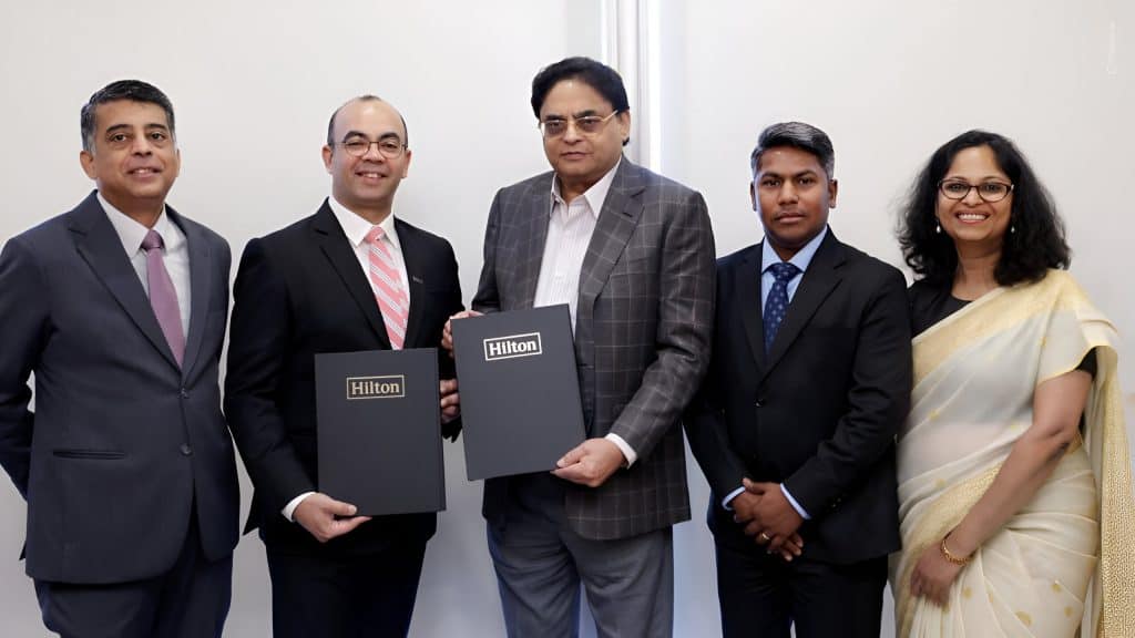 Business signing event with Hilton representatives.