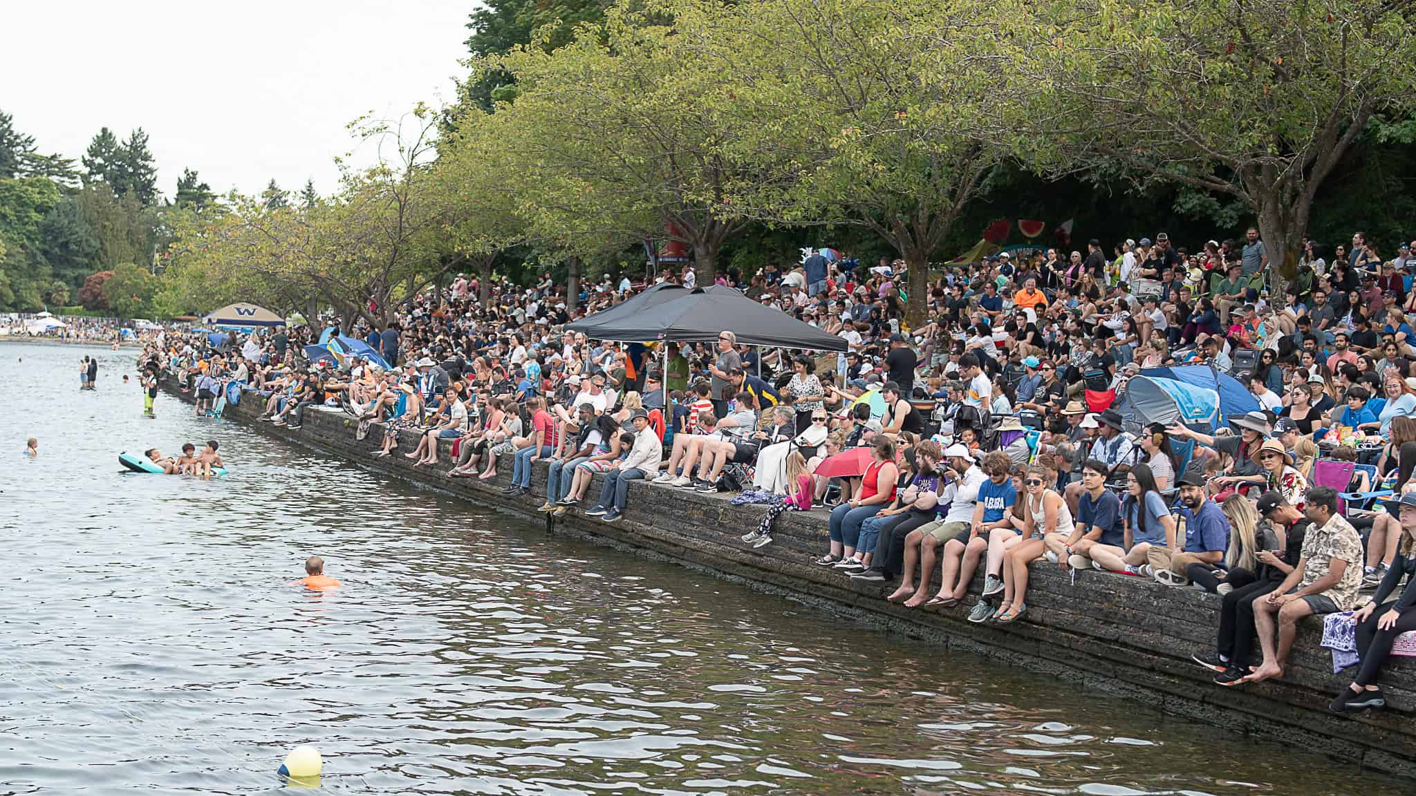 Crowds gather by the water for a classic summer festival day