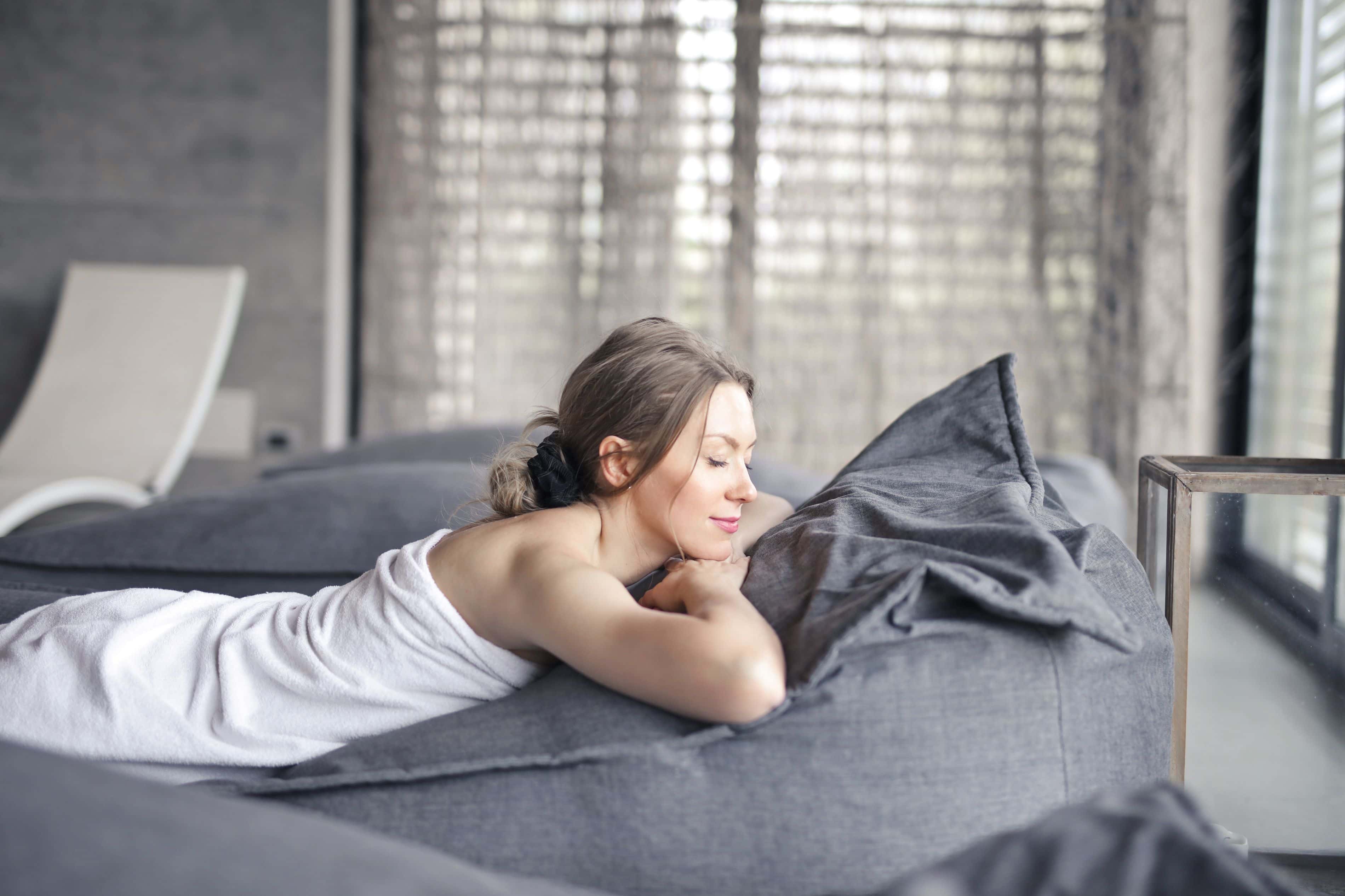 A woman relaxes on a couch, enjoying a peaceful day. Courtesy: Andrea Piacquadio, Pexels