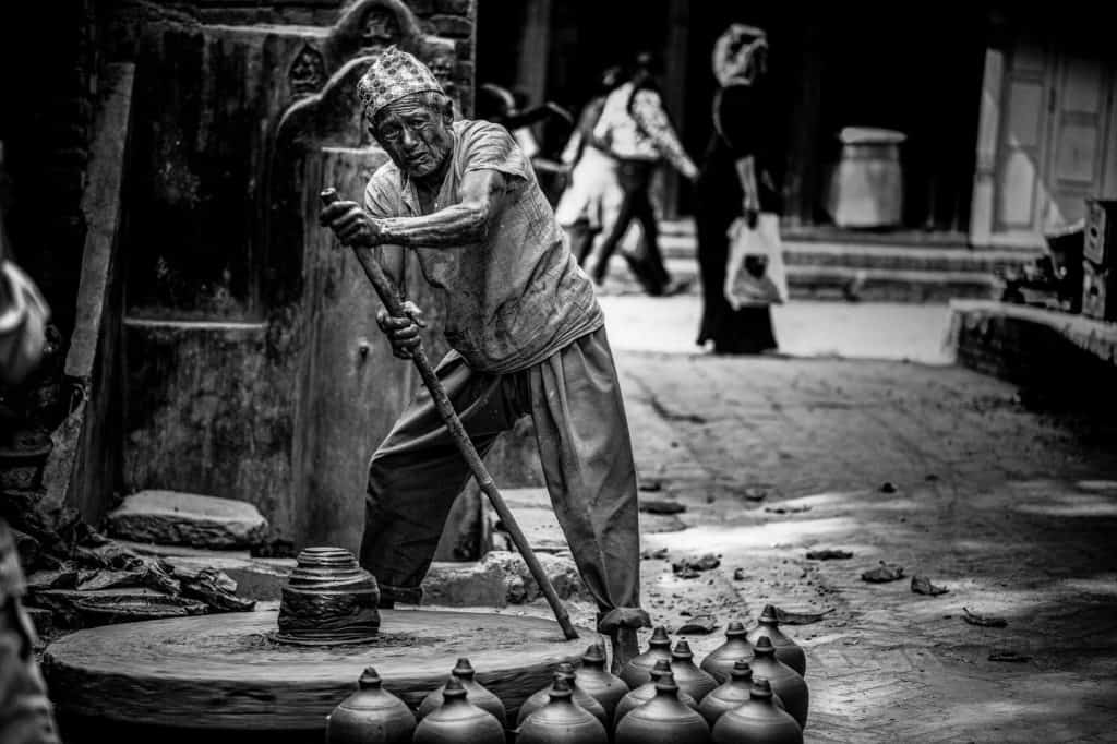 A senior man crafting pottery on a wheel in Kathmandu, Bhaktapur, Nepal, capturing traditional skills in black and white. Image Courtesy: Betadyne, Pexels